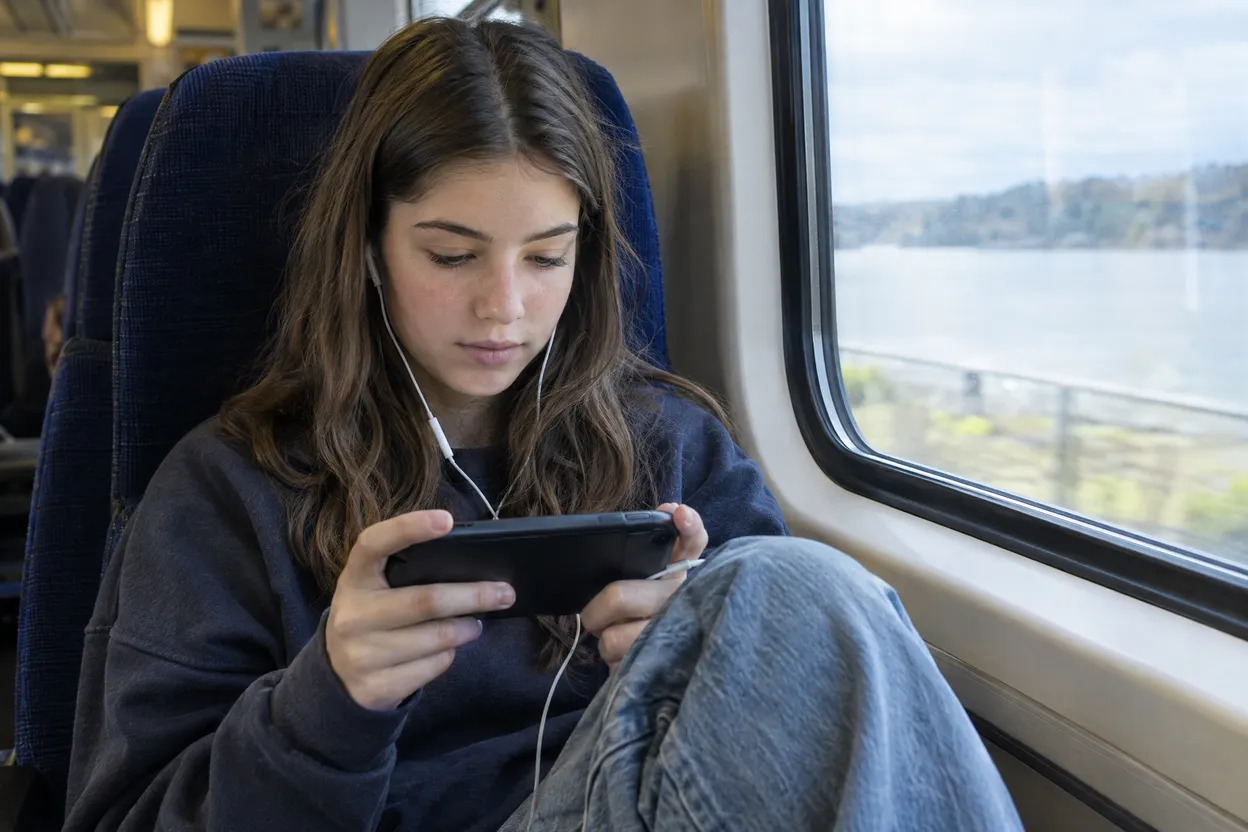 Adolescente qui regarde une vidéo sur son téléphone dans le train