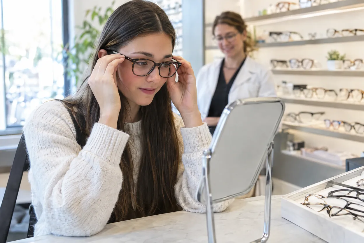 Étudiante qui essaie des lunettes chez un opticien